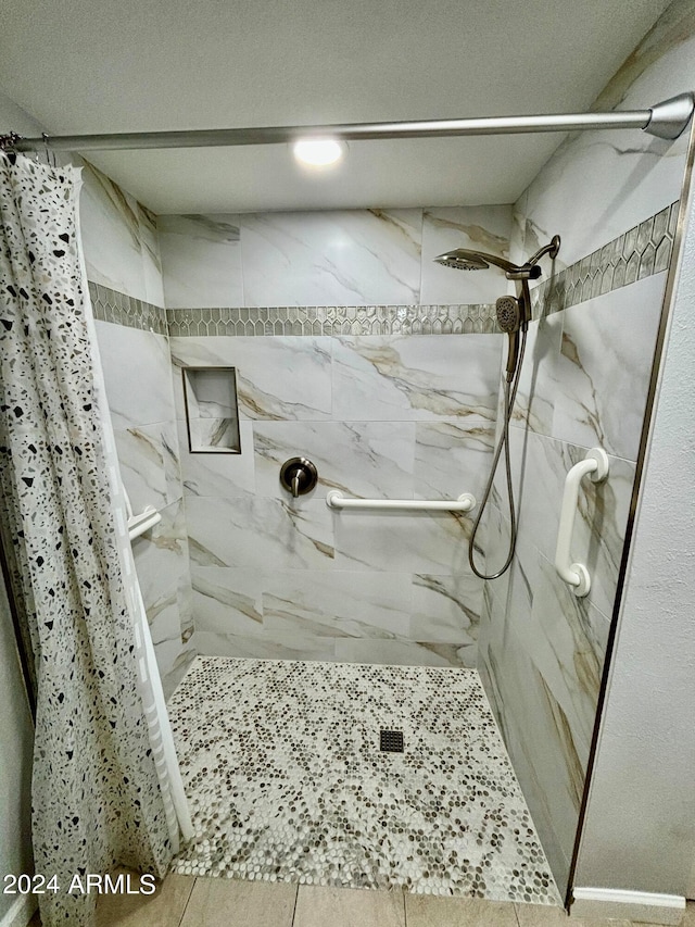 bathroom with tile patterned flooring and walk in shower