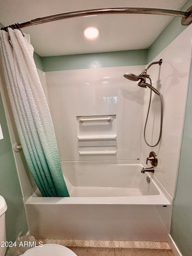 bathroom featuring toilet and shower / tub combo with curtain