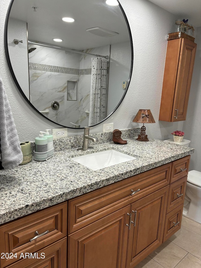 bathroom featuring tile patterned floors, vanity, toilet, and walk in shower