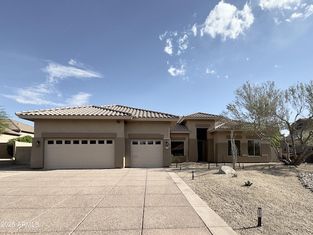 prairie-style house featuring stucco siding, an attached garage, concrete driveway, and a tiled roof