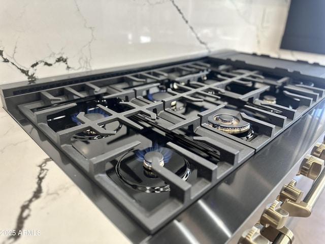 kitchen view of cooktop and light stone countertops