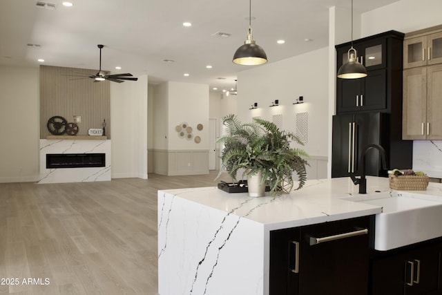 kitchen featuring a sink, high end black fridge, open floor plan, ceiling fan, and recessed lighting