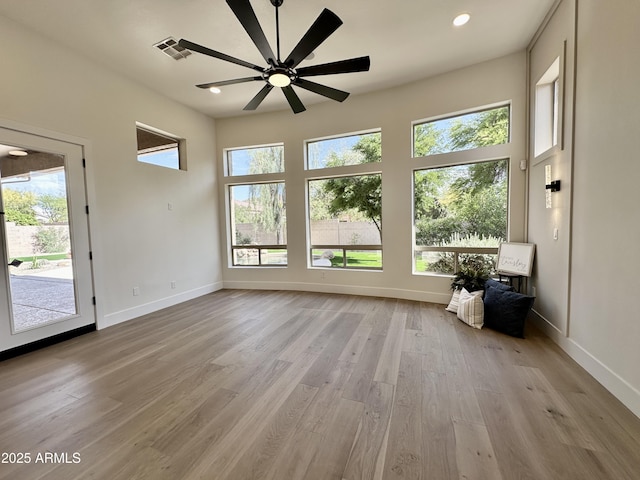 unfurnished living room with a ceiling fan, baseboards, light wood-style flooring, and recessed lighting