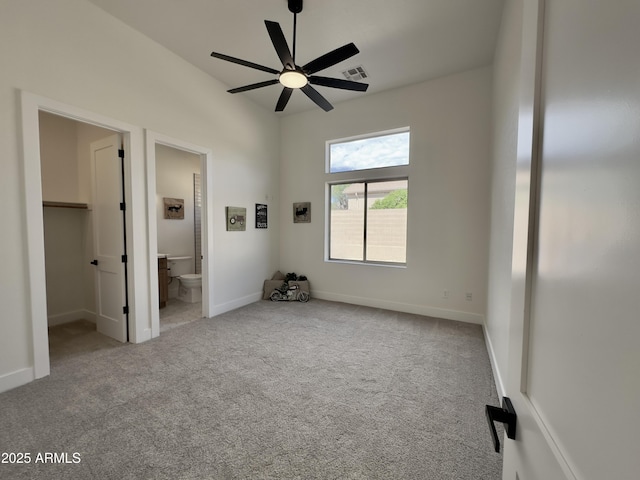 unfurnished bedroom with carpet flooring, connected bathroom, a spacious closet, and baseboards