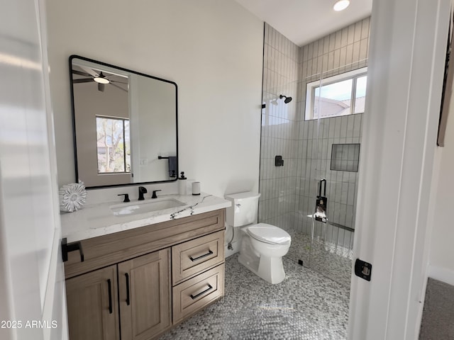 bathroom featuring a shower stall, toilet, vanity, and ceiling fan