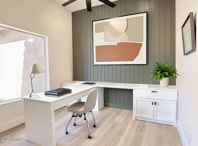 office area with ceiling fan, light wood-style flooring, baseboards, and wooden walls