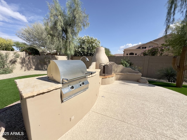 view of patio with an outdoor kitchen, a fenced backyard, and area for grilling