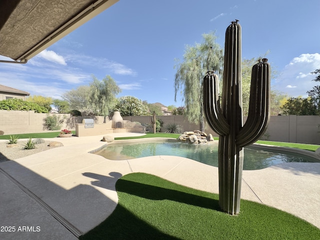 view of pool featuring a fenced backyard, a patio area, and exterior kitchen