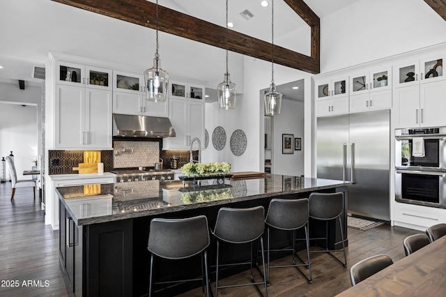 12228 E Wood Dr, Chandler, AZ 85249 - kitchen with tasteful backsplash, dark wood-style floors, under cabinet range hood, beam ceiling, and appliances with stainless steel finishes