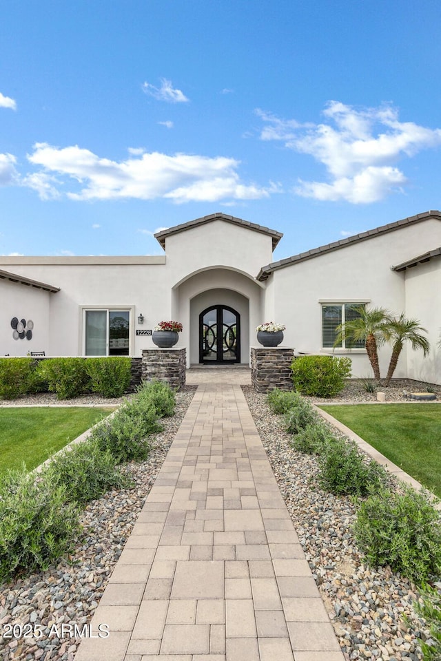 12228 E Wood Dr, Chandler, AZ 85249 - view of exterior entry featuring a yard, french doors, and stucco siding