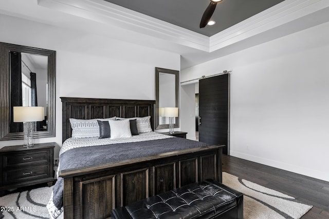 12228 E Wood Dr, Chandler, AZ 85249 - bedroom featuring dark wood-type flooring, a ceiling fan, a barn door, a raised ceiling, and baseboards