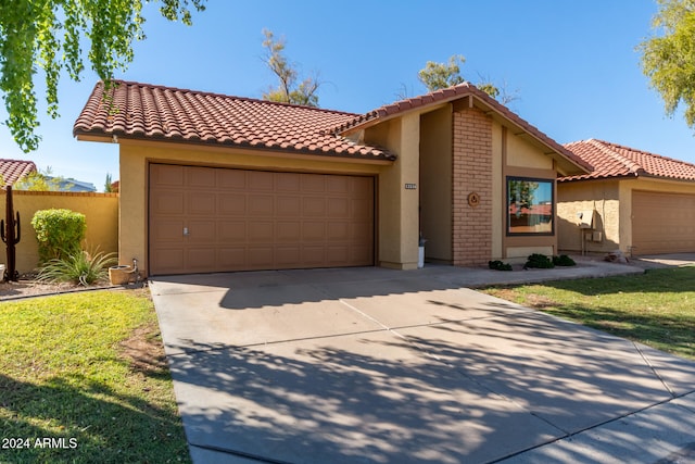 mediterranean / spanish-style house featuring a front yard and a garage