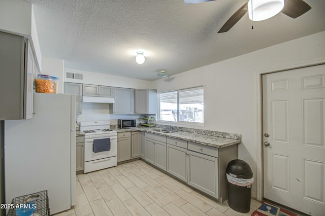 2022 W Atlanta Ave, Phoenix, AZ 85041 - kitchen with white appliances, gray cabinets, visible vents, and under cabinet range hood