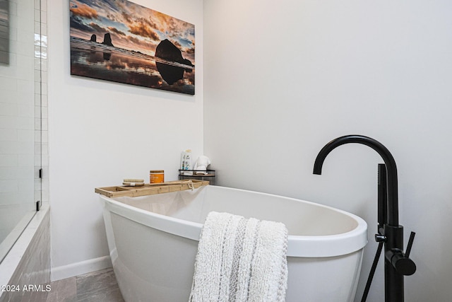 bathroom with tile patterned flooring and a tub