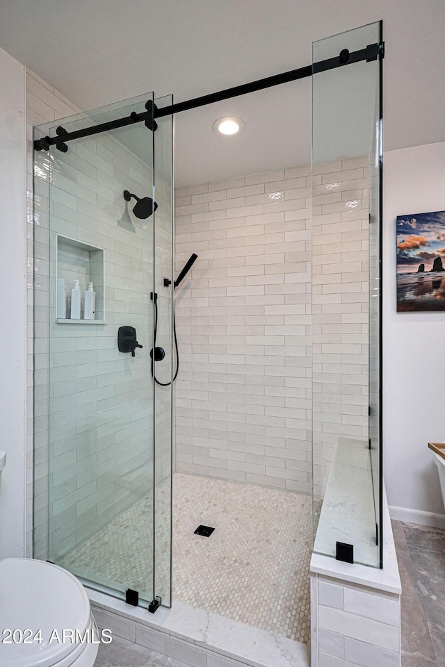 bathroom with toilet and a shower with shower door