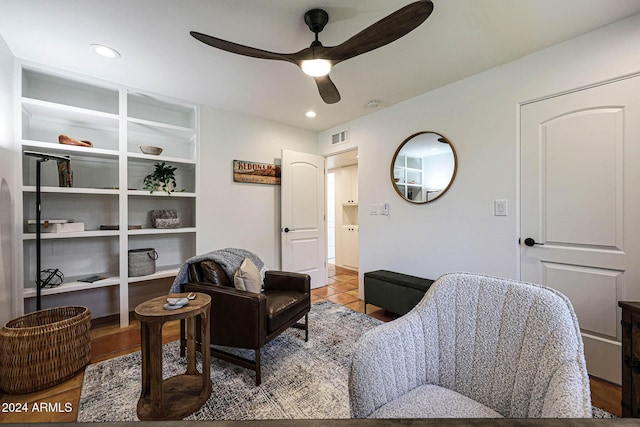 living area with ceiling fan and light tile patterned floors