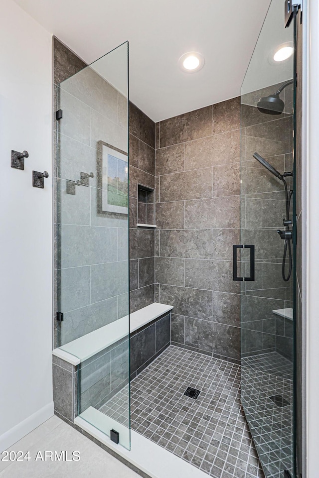 bathroom with tile patterned floors and a shower with door