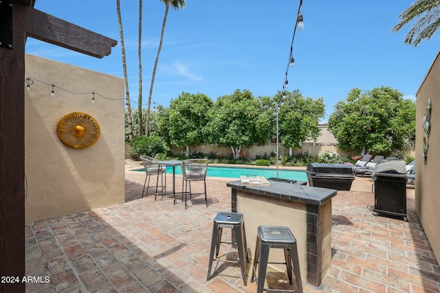 view of patio with a fenced in pool and exterior bar