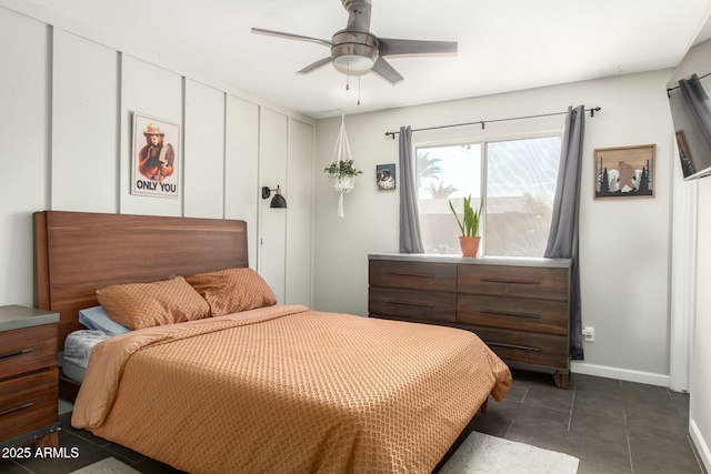 bedroom with dark tile patterned floors, baseboards, and ceiling fan