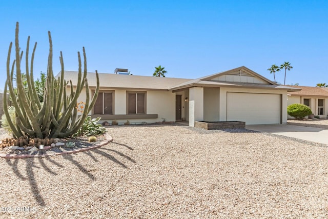 single story home featuring stucco siding, an attached garage, and driveway