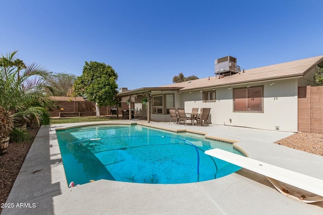 view of pool with central AC, fence, a diving board, a fenced in pool, and a patio area