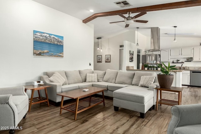 living area with a ceiling fan, visible vents, high vaulted ceiling, light wood-style flooring, and beamed ceiling