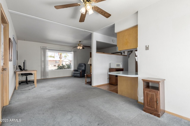 unfurnished living room with light carpet and ceiling fan