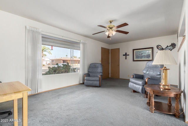 sitting room with ceiling fan and carpet flooring