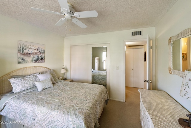 carpeted bedroom featuring ceiling fan and a textured ceiling