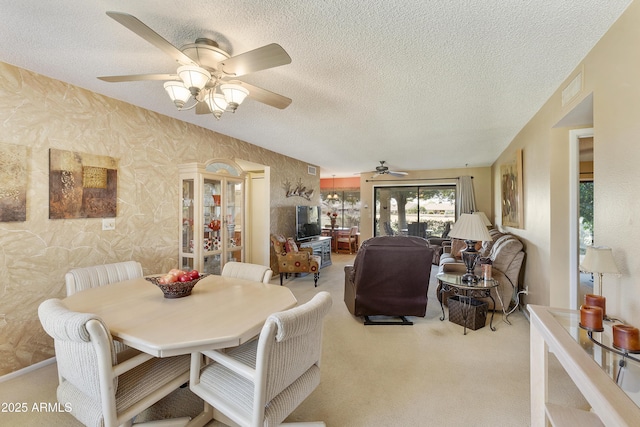 carpeted dining space with ceiling fan and a textured ceiling