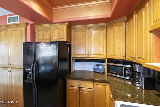 kitchen with ornamental molding and black fridge