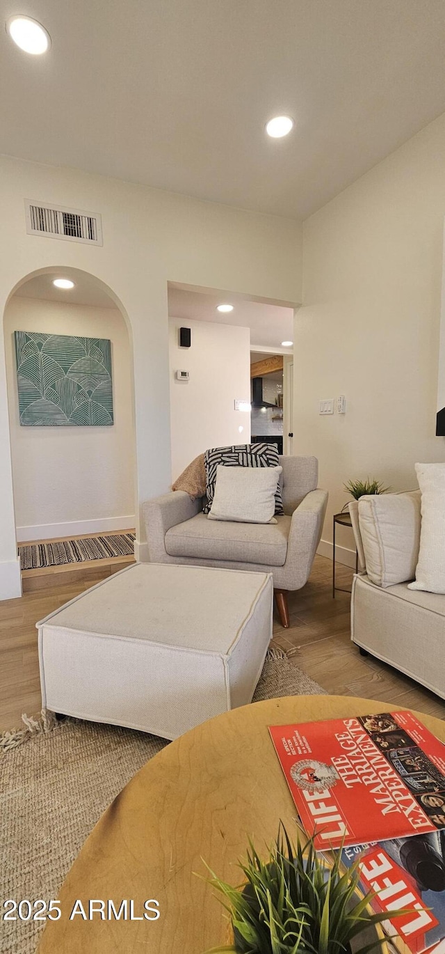 living room featuring wood finished floors, recessed lighting, baseboards, and visible vents