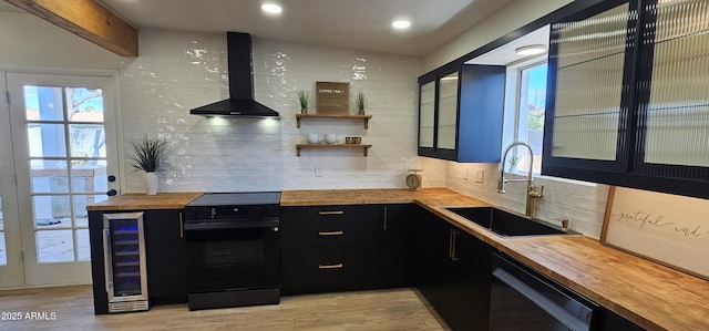 kitchen with butcher block countertops, dishwasher, dark cabinets, wall chimney range hood, and electric range