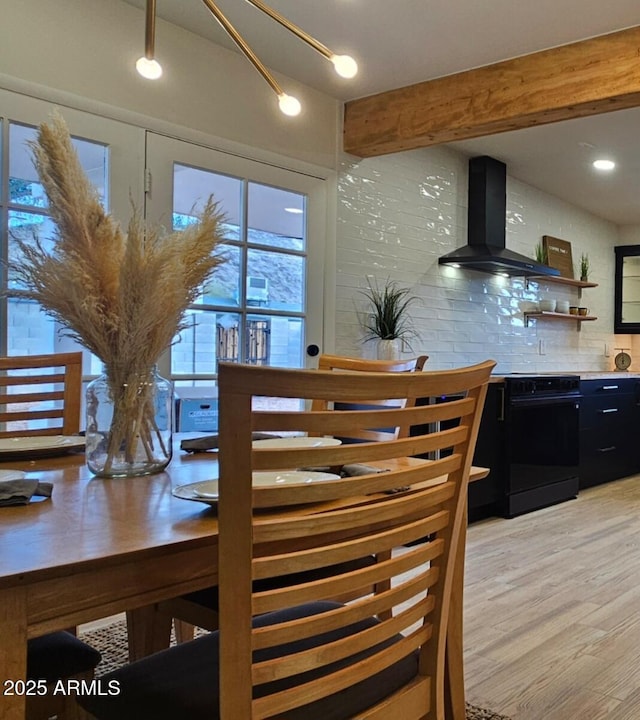dining room with light wood-style flooring and beamed ceiling