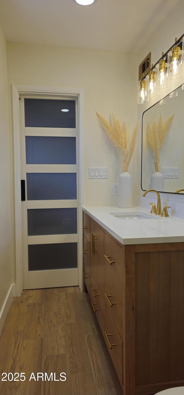 bathroom with wood finished floors and vanity