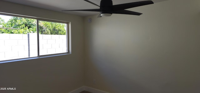 spare room with baseboards and ceiling fan