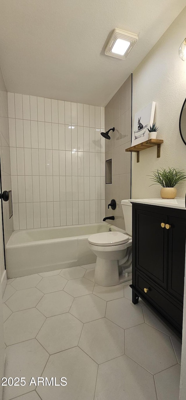 full bath with tile patterned floors, toilet, vanity, and shower / washtub combination