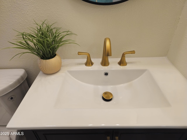 details with a textured wall and vanity