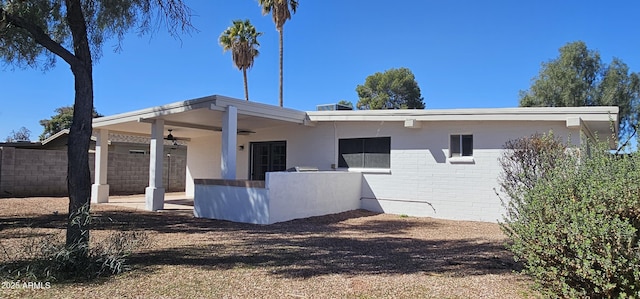 view of home's exterior featuring an attached carport, brick siding, fence, and a patio area