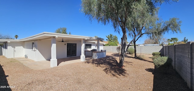 rear view of property with a fenced backyard, stucco siding, ceiling fan, and a patio