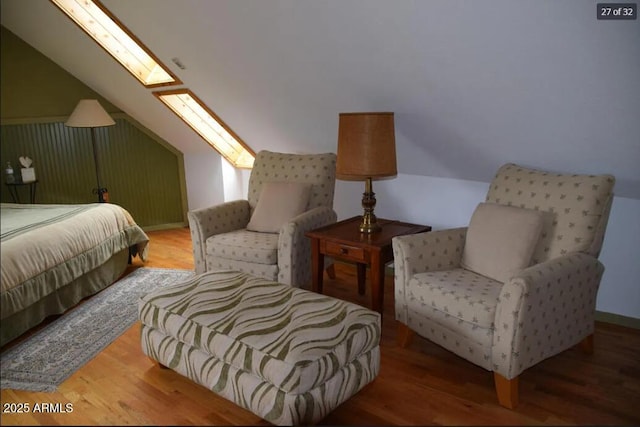 interior space featuring hardwood / wood-style flooring and lofted ceiling with skylight