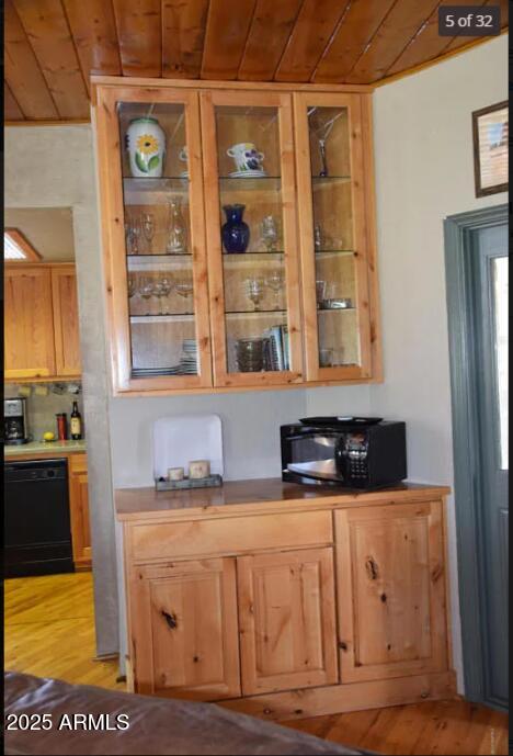 kitchen with black appliances, light hardwood / wood-style floors, and wooden ceiling