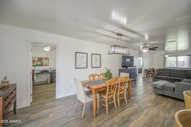 dining area with visible vents, a ceiling fan, and wood finished floors