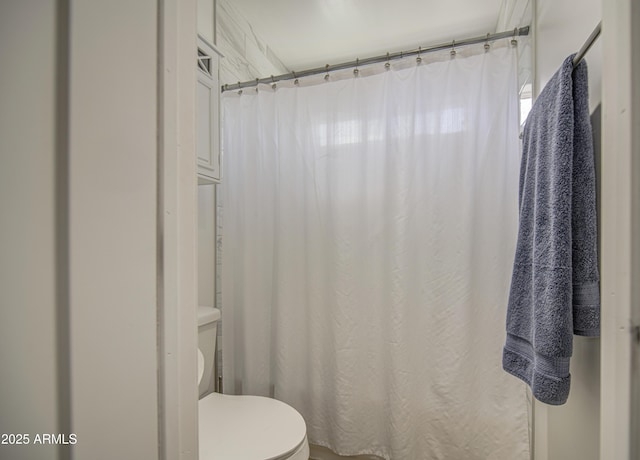 full bathroom featuring a shower with curtain and toilet
