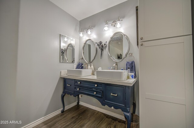 bathroom with baseboards, wood finished floors, and vanity