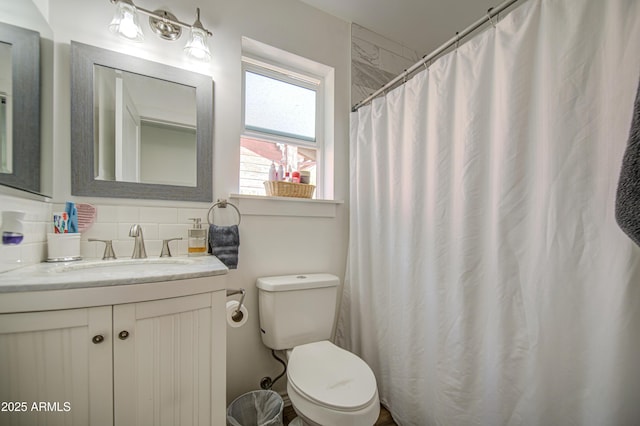 bathroom featuring curtained shower, toilet, backsplash, and vanity