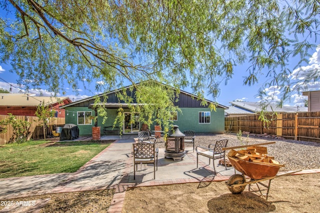 view of patio with area for grilling, a fenced backyard, and a fire pit