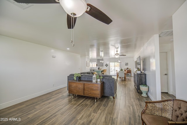 living area featuring baseboards, wood finished floors, and a ceiling fan