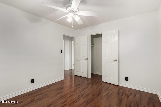 unfurnished bedroom featuring dark hardwood / wood-style flooring, ceiling fan, and a closet