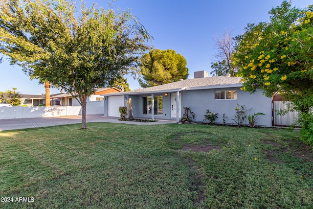 ranch-style home featuring a garage and a front lawn